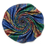 This image showcases a cross-section of a spiral shell featuring a mesmerizing array of colors and intricate patterns. The vibrant hues range from pink, blue, and green near the center to yellow, orange, and brown towards the outer edges, creating a stunn