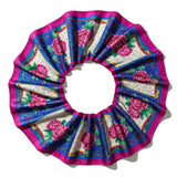 This image showcases a cross-section of a spiral shell featuring a mesmerizing array of colors and intricate patterns. The vibrant hues range from pink, blue, and green near the center to yellow, orange, and brown towards the outer edges, creating a stunn